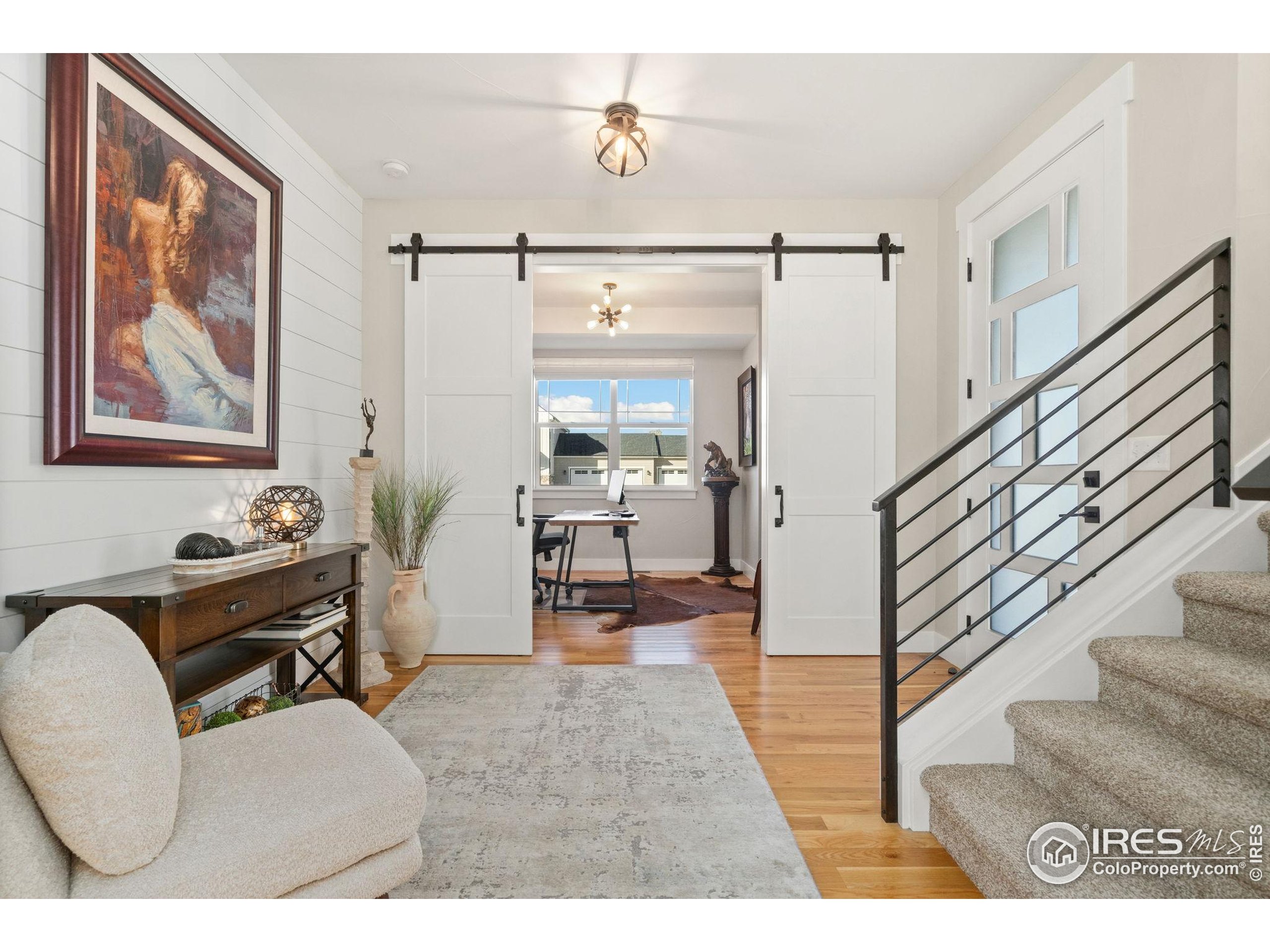 2032 Cuda Court Berthoud, CO 80513 - Photo 5 of 38 a living room with furniture and a dining table with wooden floor