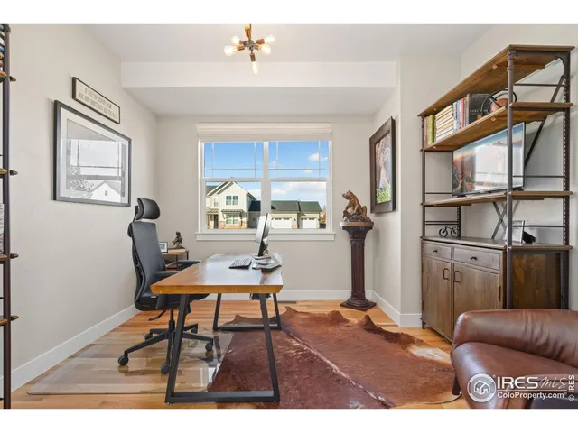 a view of a workspace with furniture and a window