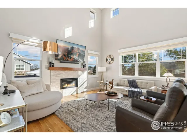 a living room with furniture a fireplace and a large window
