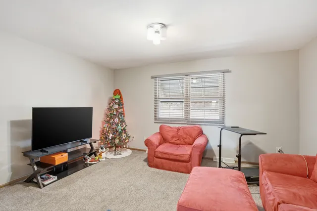 a living room with furniture a flat screen tv and a window