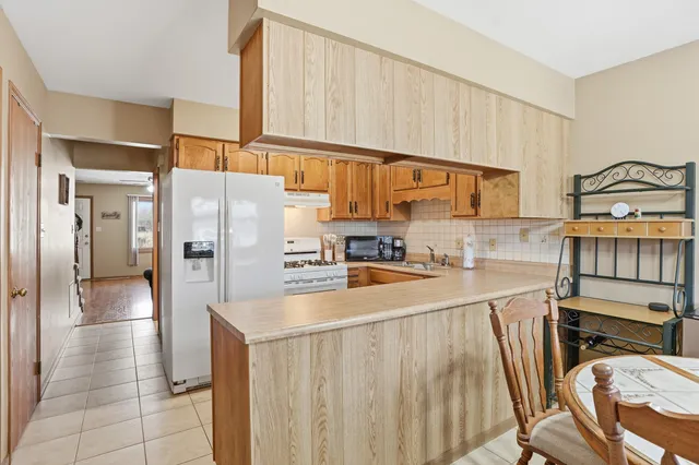a kitchen with stainless steel appliances granite countertop a refrigerator a stove and a sink with cabinets