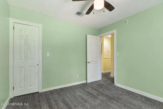 an empty room with closet and windows