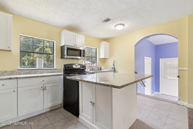 a kitchen with a sink cabinets and window