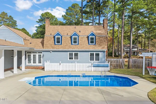 a view of house with yard and large trees
