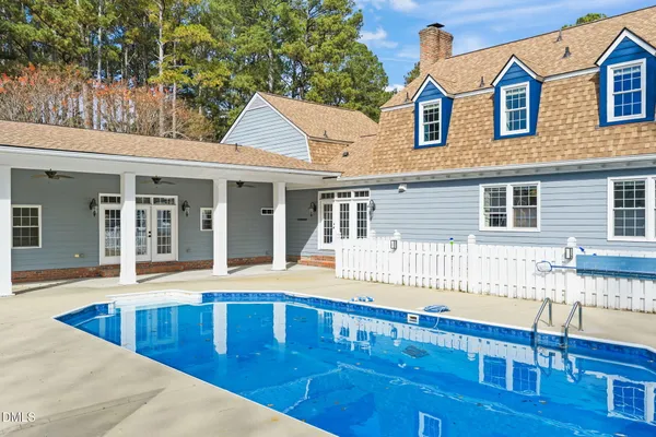 an aerial view of a house with swimming pool and outdoor seating