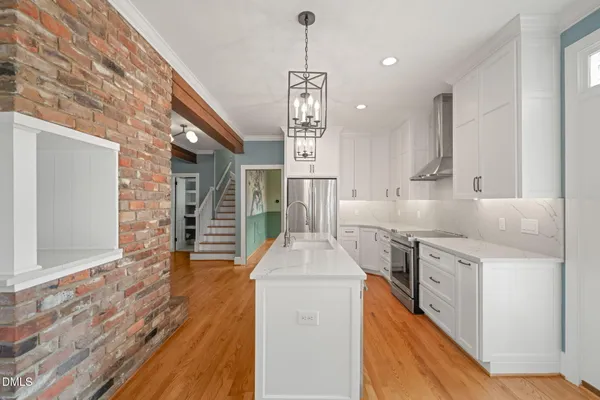 a kitchen with stainless steel appliances kitchen island granite countertop a stove and a sink