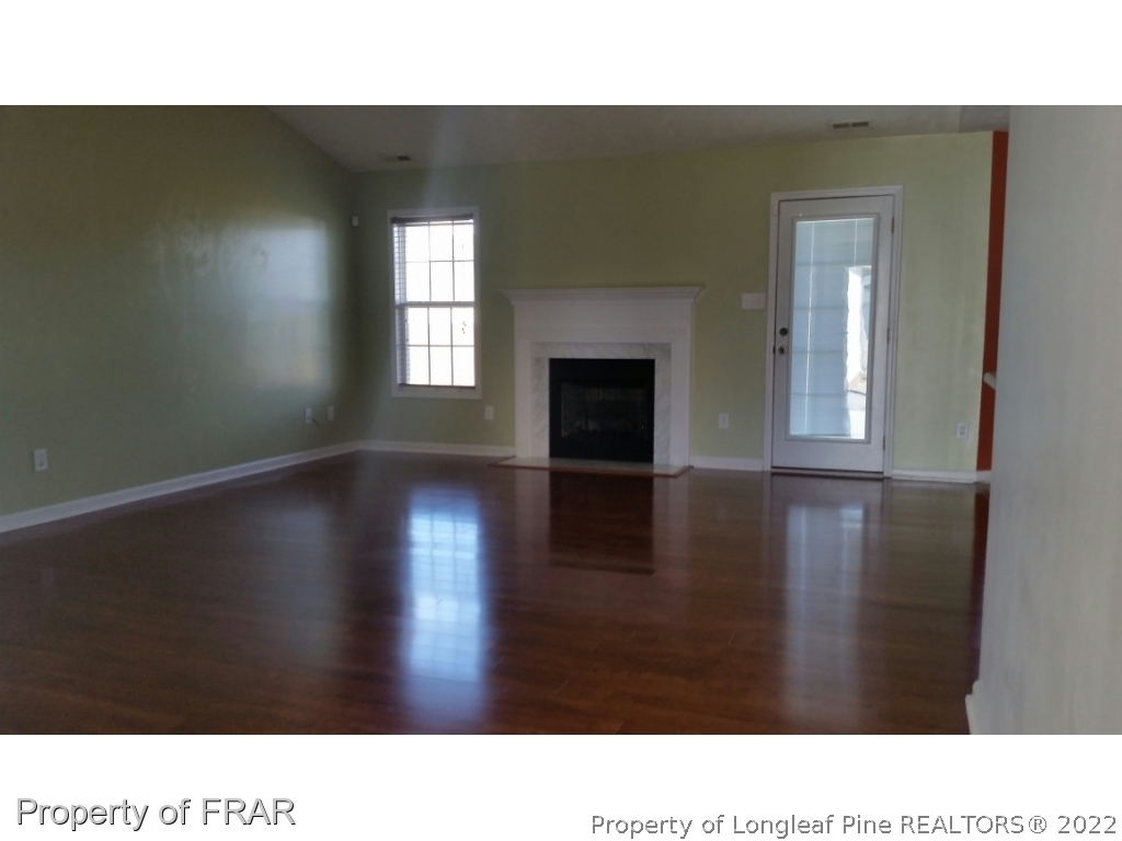 1953 Yellowbrick Road Fayetteville, NC 28314 - Photo 4 of 8 a open hall with a floor to ceiling window and wooden floor