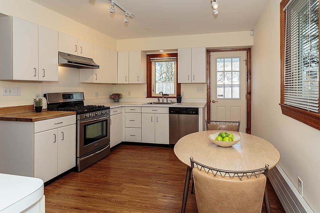 29 Ware Road Newton, MA 02466 - Photo 9 of 25 a kitchen with stainless steel appliances a kitchen island hardwood floor sink stove dining table and chairs