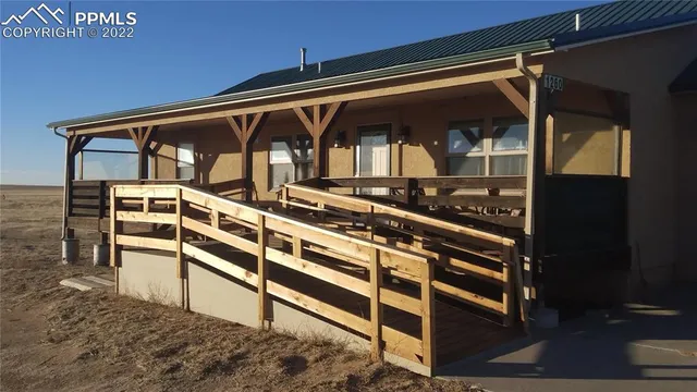 a view of a balcony with chairs and wooden floor