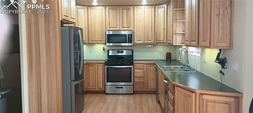 1260 County Road South Rush, CO 80833 - Photo 4 of 41 a kitchen with stainless steel appliances granite countertop a refrigerator a sink dishwasher a stove and a dining table with wooden floor