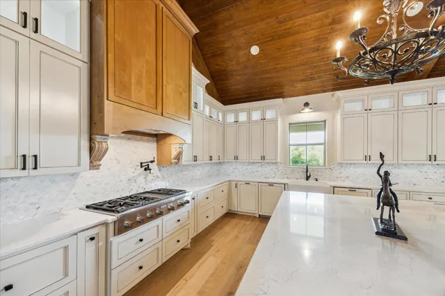 a kitchen with granite countertop a stove a sink and a refrigerator