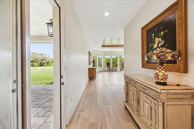 a view of a hallway with wooden floor and windows