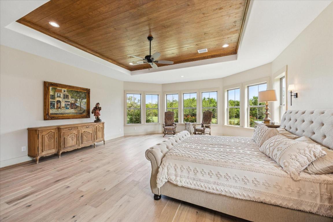 2130 Hartfield Road Round Top, TX 78954 - Photo 20 of 39 a spacious bedroom with a bed painting on wall and a large window