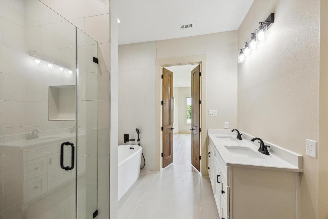 2130 Hartfield Road Round Top, TX 78954 - Photo 25 of 39 a bathroom with a double vanity sink a mirror and a shower