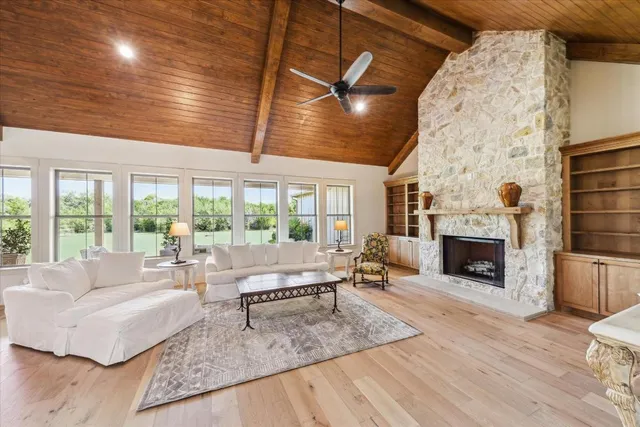 a living room with furniture large window and fireplace