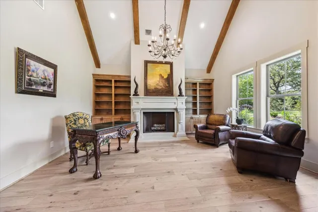 a living room with furniture a fireplace and a chandelier
