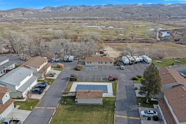 an aerial view of residential houses with outdoor space and trees
