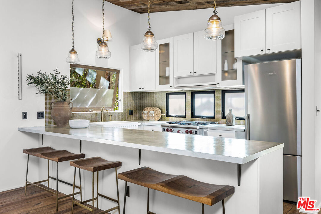 2211 Glencoe Avenue Venice, CA 90291 - Photo 4 of 19 a kitchen with stainless steel appliances granite countertop a refrigerator a sink a stove and white cabinets