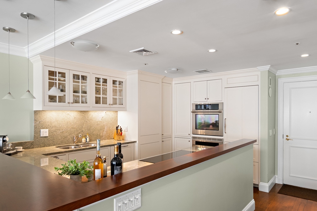 300 Boylston Street, Unit 909 Boston, MA 02116 - Photo 5 of 18 a view of a kitchen with stainless steel appliances granite countertop a sink and a refrigerator