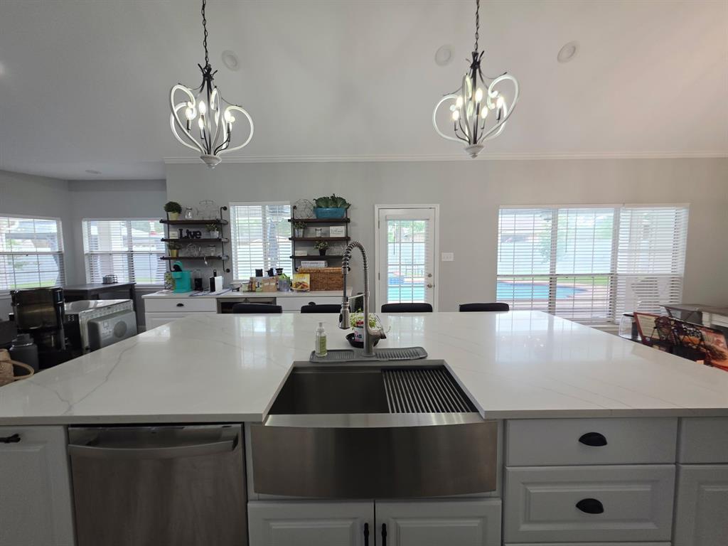 520 Red River Road Belton, TX 76513 - Photo 21 of 36 Spacious kitchen island featuring a farmhouse-style sink, white cabinetry with dark hardware, a stainless steel dishwasher, and a light-colored countertop