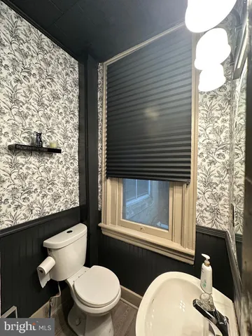 a bathroom with a toilet a sink and a window
