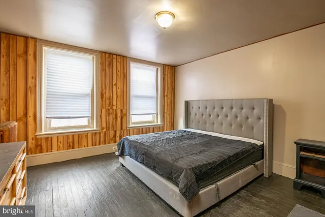a bed sitting in a spacious bedroom next to a window