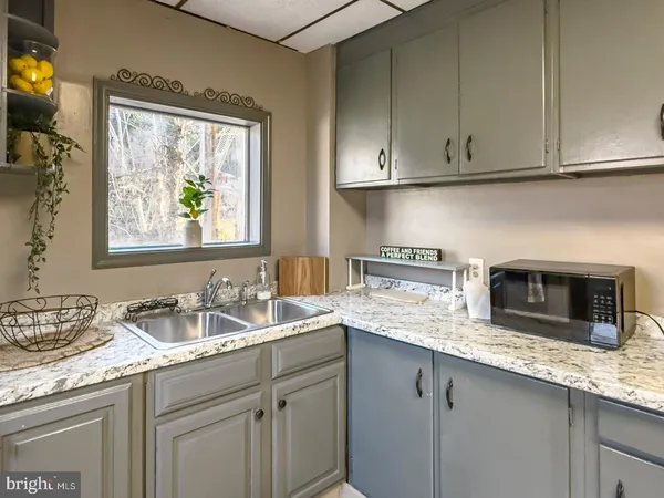 a kitchen with granite countertop stainless steel appliances a sink stove and cabinets