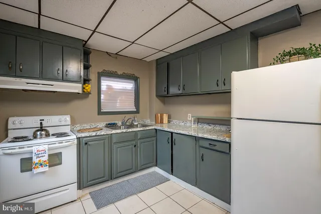 a kitchen with a sink a refrigerator and cabinets
