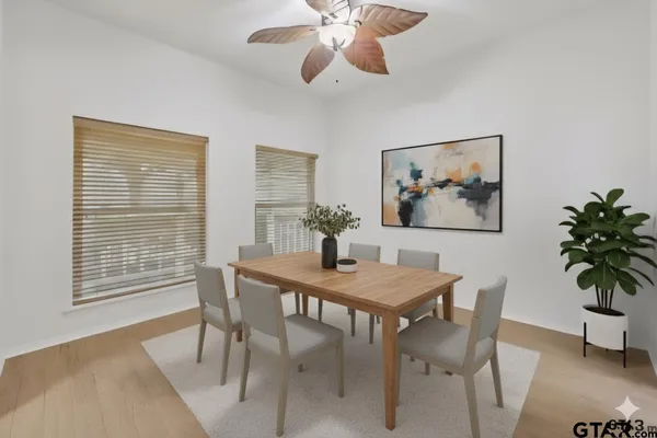 a dining room with furniture potted plants and wooden floor