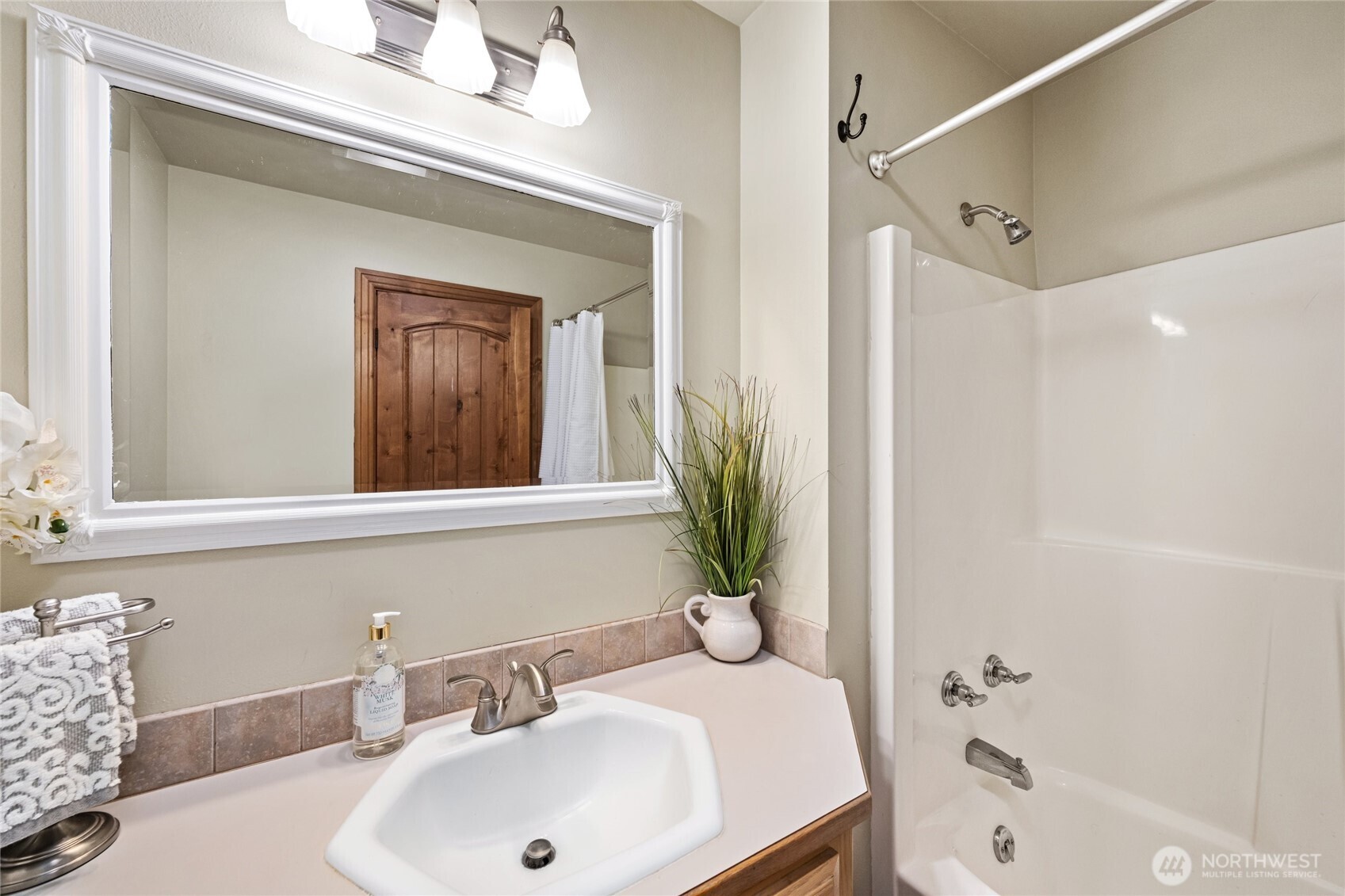 770 East Wiser Lake Road Lynden, WA 98264 - Photo 17 of 36 a bathroom with a sink a mirror and a bathtub