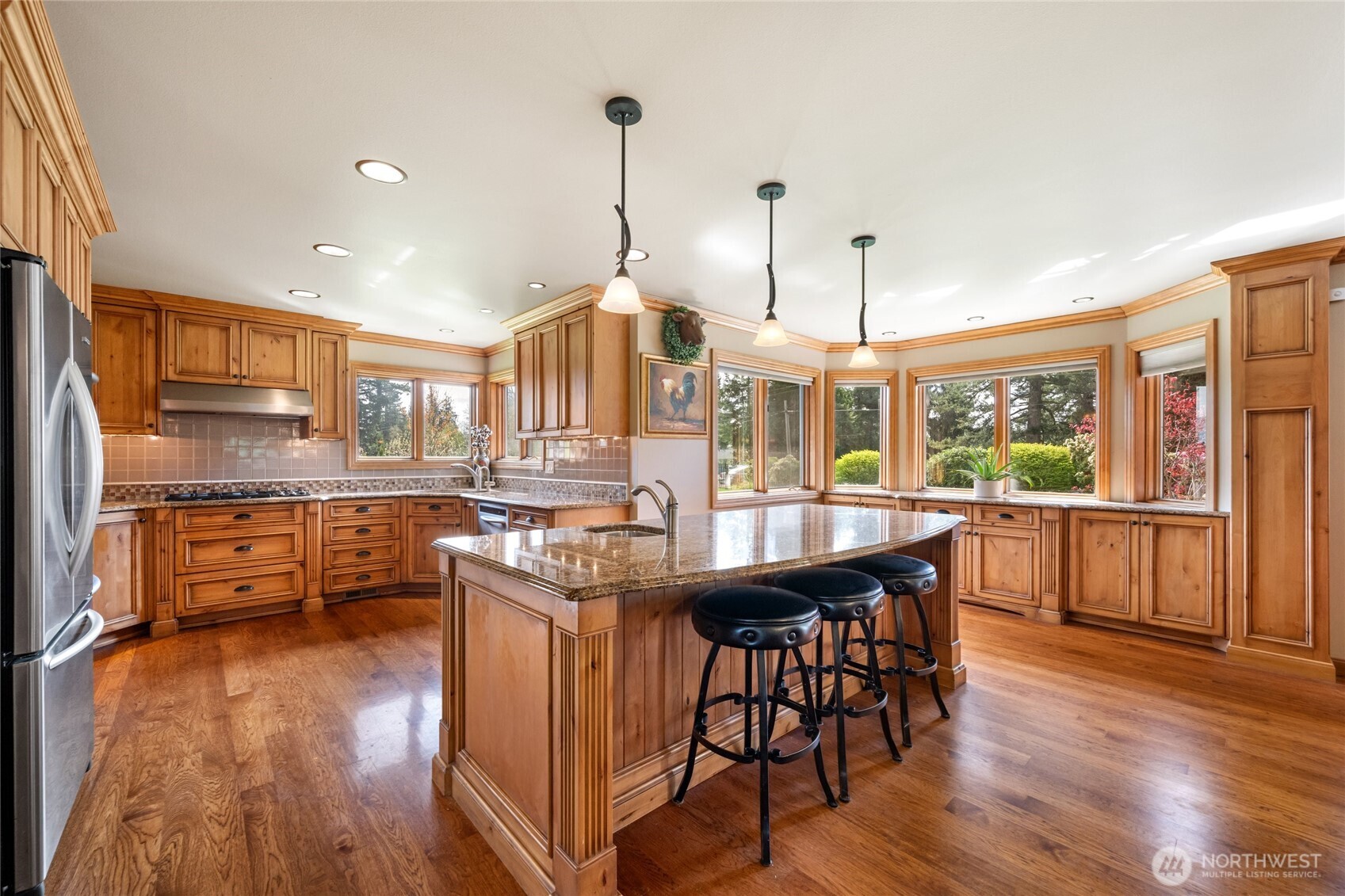 770 East Wiser Lake Road Lynden, WA 98264 - Photo 6 of 36 a kitchen with stainless steel appliances granite countertop a stove a refrigerator a kitchen island a dining table and chairs with wooden floor