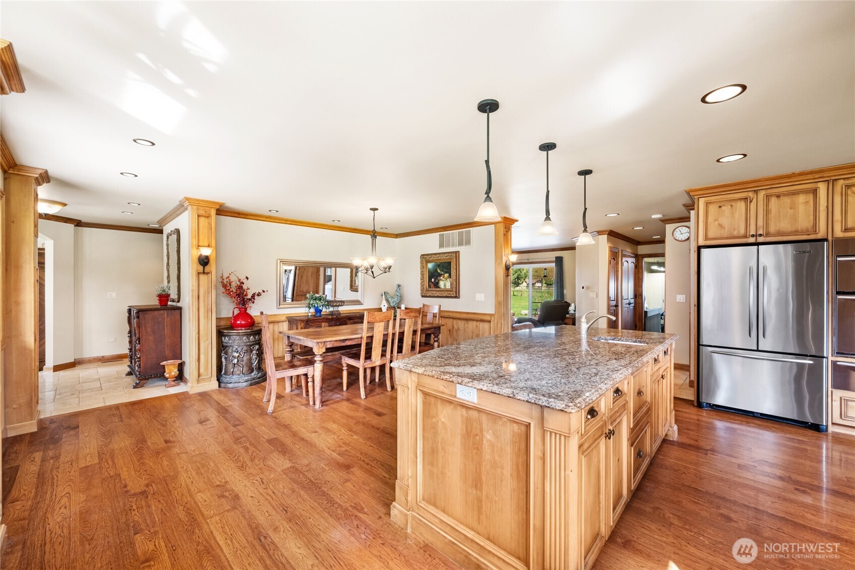 770 East Wiser Lake Road Lynden, WA 98264 - Photo 8 of 36 a kitchen with stainless steel appliances granite countertop a refrigerator a sink dishwasher a dining table and chairs with wooden floor