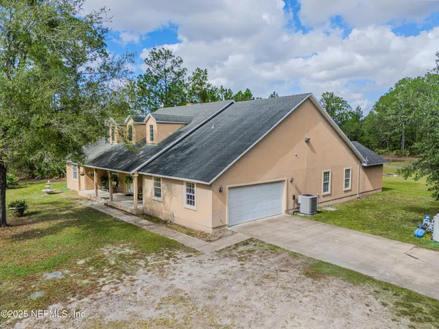 a view of a backyard with wooden fence and large trees
