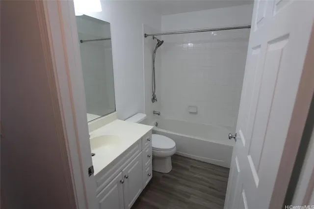 a bathroom with a granite countertop toilet a sink and shower
