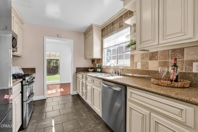 a kitchen with stainless steel appliances granite countertop a sink stove and refrigerator