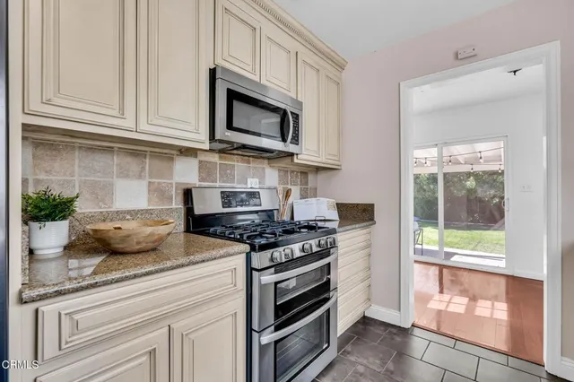 a kitchen with granite countertop cabinets stainless steel appliances and a counter space