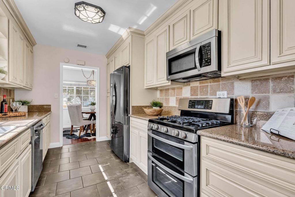 472 Geneva Avenue Claremont, CA 91711 - Photo 17 of 50 a kitchen with stainless steel appliances granite countertop a stove top oven a refrigerator cabinets and a view of living room
