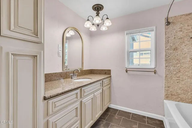 a bathroom with a granite countertop sink a mirror and a vanity