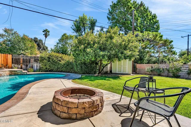 a swimming pool with outdoor seating yard and green space