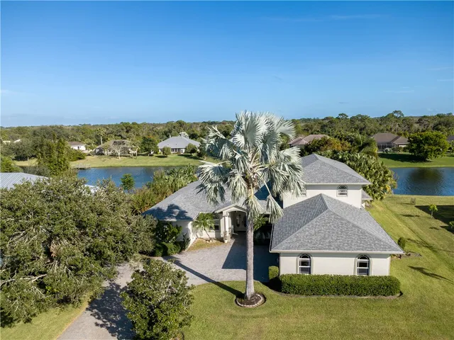 an aerial view of residential houses with outdoor space and lake view
