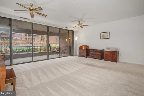 a spacious bedroom with a large bed and a chandelier fan