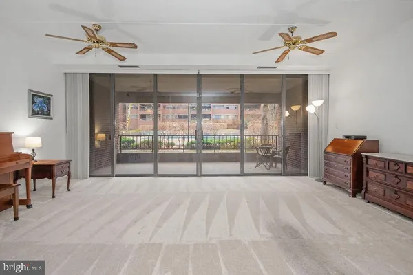 a view of a livingroom with a ceiling fan and a large window