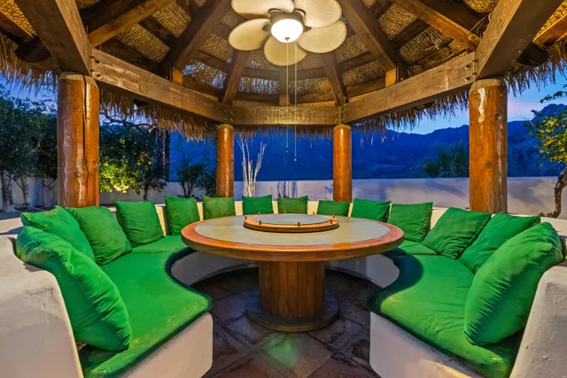 a view of a patio with table and chairs potted plants and palm tree