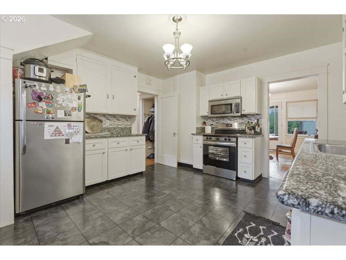 706 West B Street Rainier, OR 97048 - Photo 12 of 47 a kitchen with kitchen island granite countertop a stove top oven a sink a counter space and cabinets