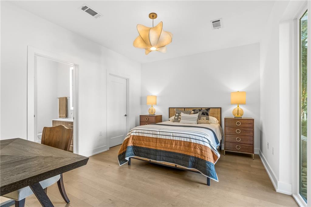 775 Juniper Street Northeast, Unit 309 Atlanta, GA 30308 - Photo 8 of 49 a bedroom with a bed and a chandelier