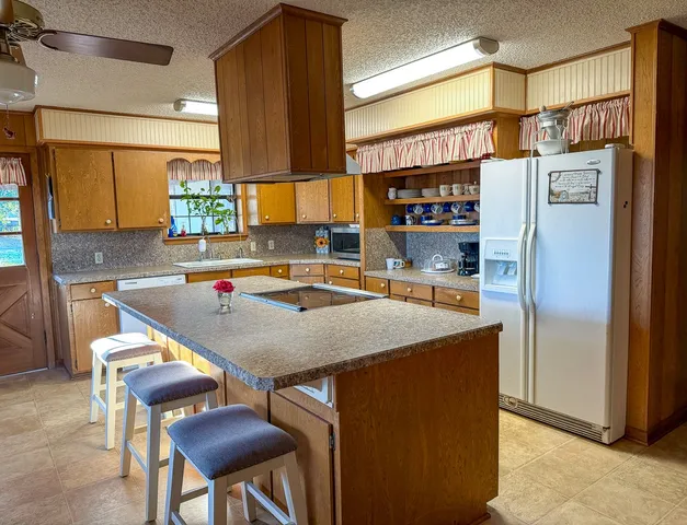 a room with stainless steel appliances furniture a refrigerator and a window