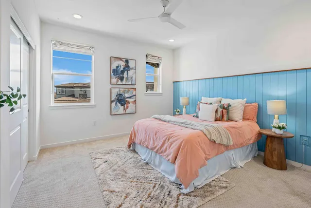 a bedroom with a large bed and a potted plant
