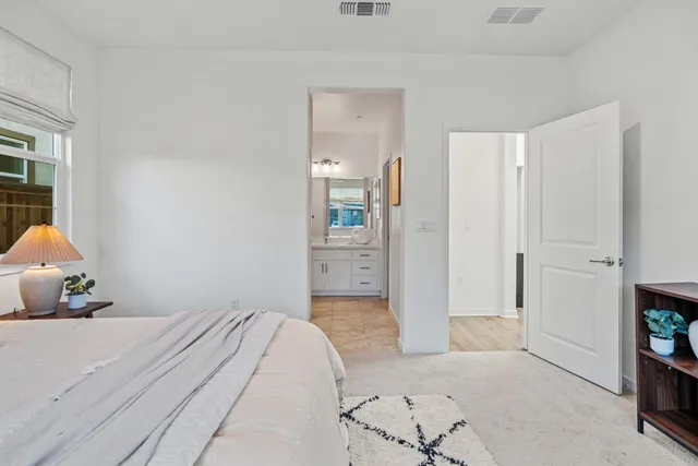 a bedroom with a bed and a refrigerator