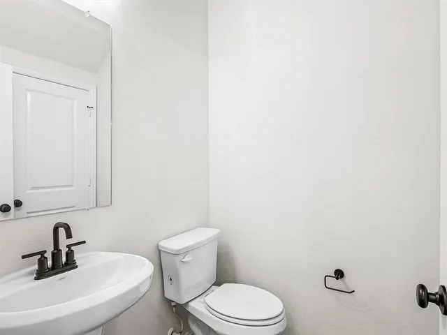 a bathroom with a sink a toilet and mirror