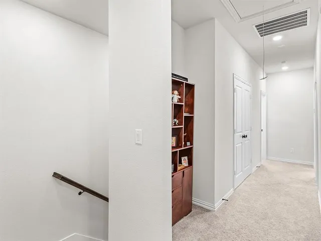 a view of a hallway with wooden cabinets